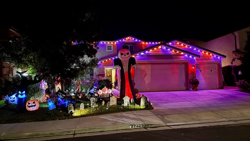 Home decorated for Halloween with purple and orange roofline lights
