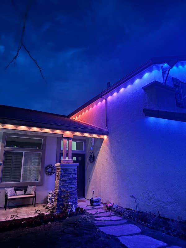 Home lit in blue and purple accent lights along the eaves